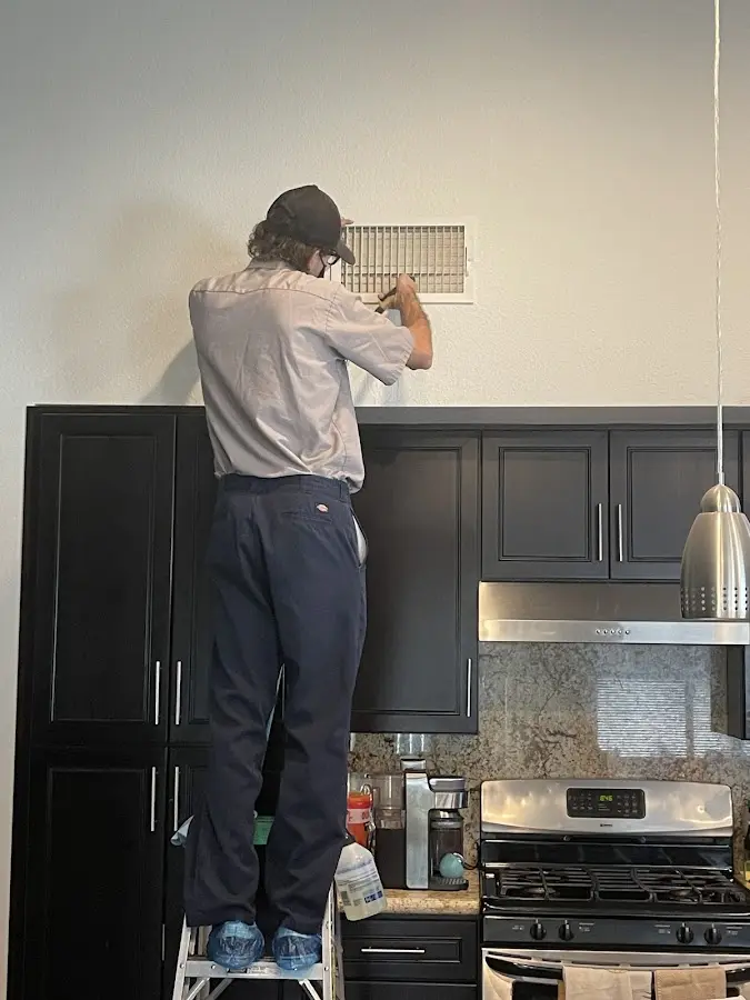 Technician inspecting an air vent during HVAC service in Brooklyn Center